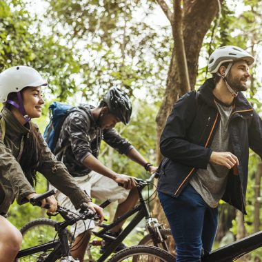 Group of friends ride mountain bike in the forest together
