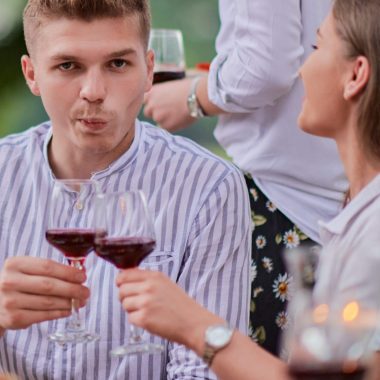 group of happy friends having picnic french dinner party outdoor during summer holiday vacation near the river at beautiful nature