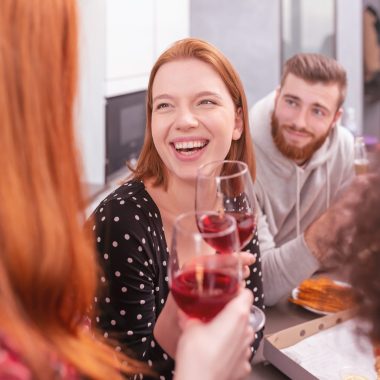 Happy friends meet for an aperitif at home